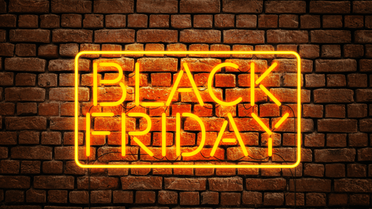 Neon sign reading 'Black Friday' glowing against a brick wall background.