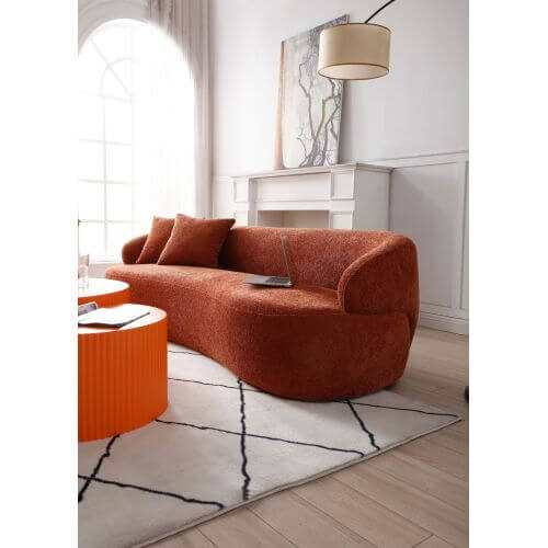 Modern curved 3 seat sofa in boucle fabric, showcased in stylish living room with window, artwork, and orange table