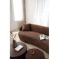 Modern curved boucle fabric 3 seat sofa in a living room with a book and drink on coffee tables