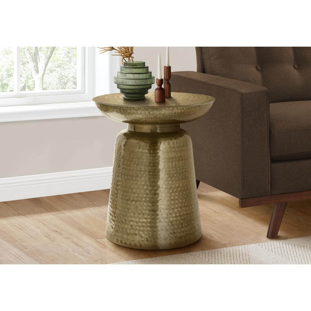 Hammered metal round drum accent end table with bell-shaped base in living room setting.