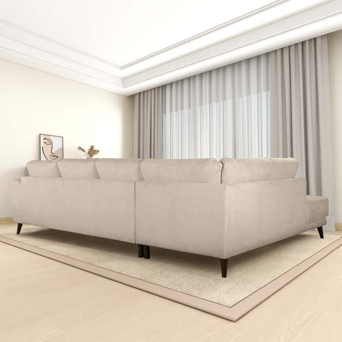 Mid-century modern cream-colored left facing chaise sectional sofa in spacious, elegant living room with natural light and floor-to-ceiling curtains