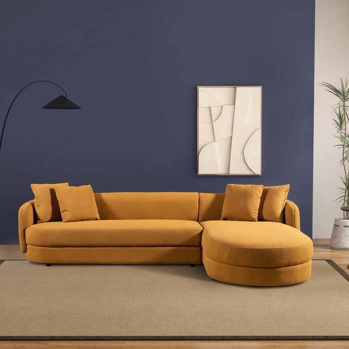 Chandler Boucle Right Facing Chaise Sectional Sofa in mustard yellow shown in a modern living room setting against a blue wall.