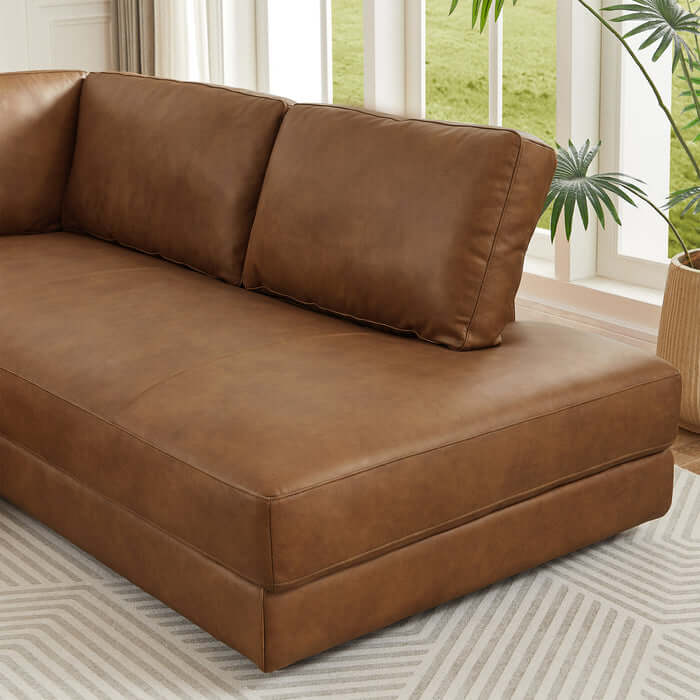 Brown leather sectional chaise sofa in modern living room setting with natural light.