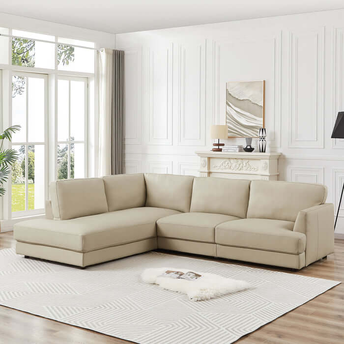 Modern living room with Glander Leather Sectional Chaise Sofa 108" in beige against a white paneled wall and large windows