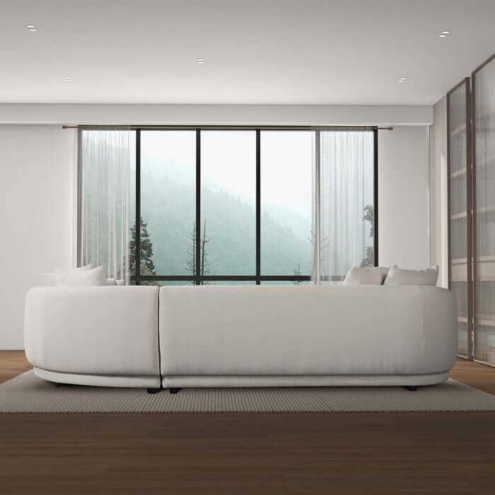 Highline Boucle Corner Sectional Sofa with sleek spherical profile in modern Japandi living room with large window and mountain view.