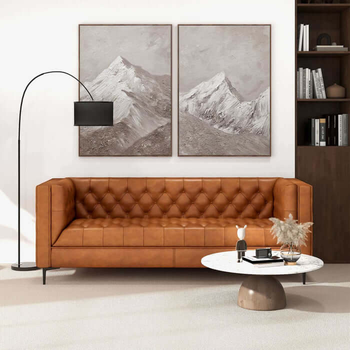 Evelyn MCM Tufted Tan Leather Chesterfield Sofa in Modern Living Room Setup with Mountain Artwork