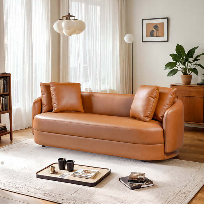 Dylan Modern Cognac Faux Leather Sofa 85" in a stylish living room setting with elegant decor and warm lighting.